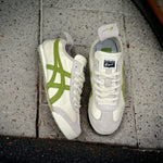 A pair of sneakers with white, green, and beige colors, featuring a lace-up closure and a logo on the side.